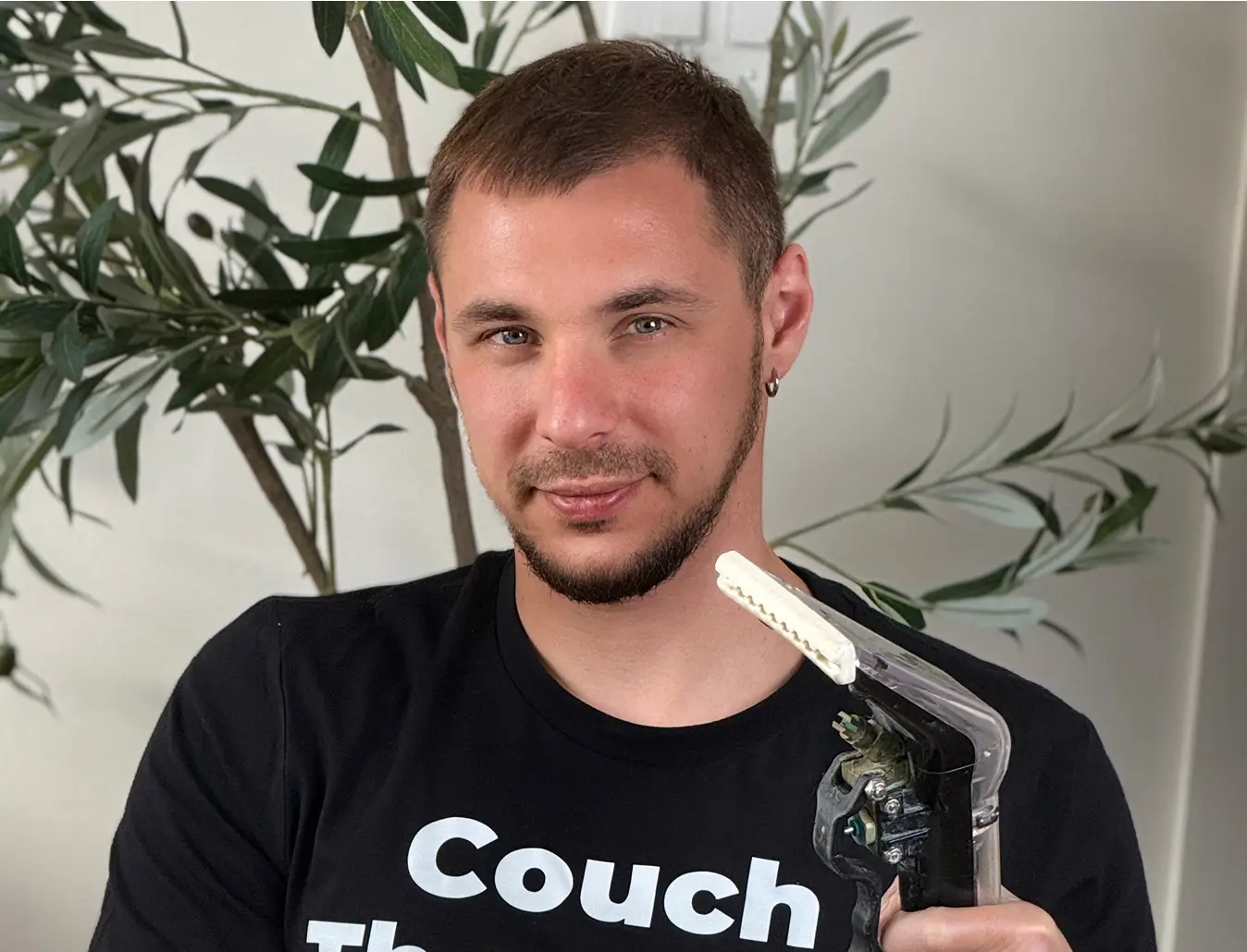 Owner of Charlotte Steamers holding professional upholstery cleaning equipment in Charlotte