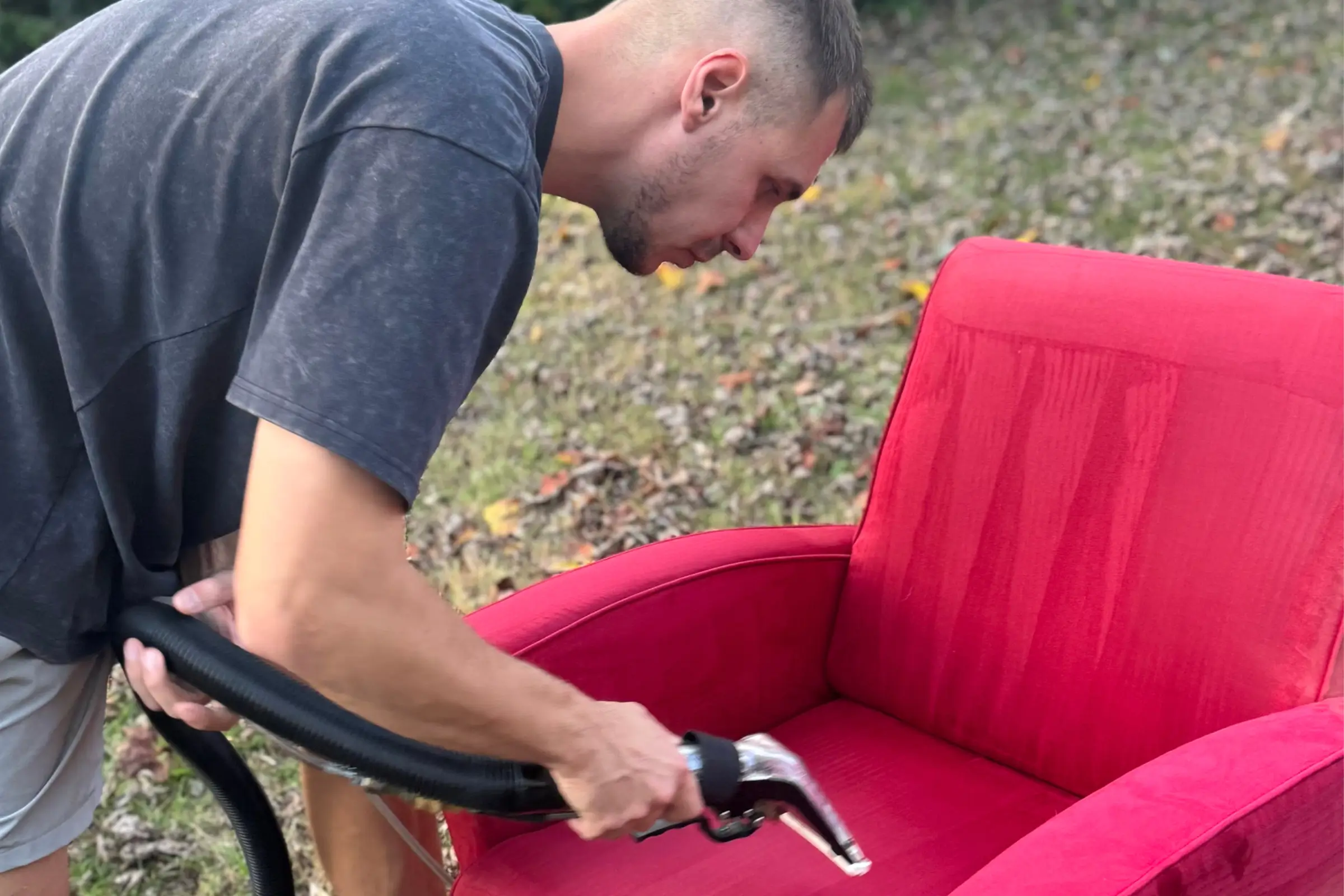 Professional steam upholstery cleaning service on a red fabric sofa outdoors in Dallas, TX by Texas Steamers