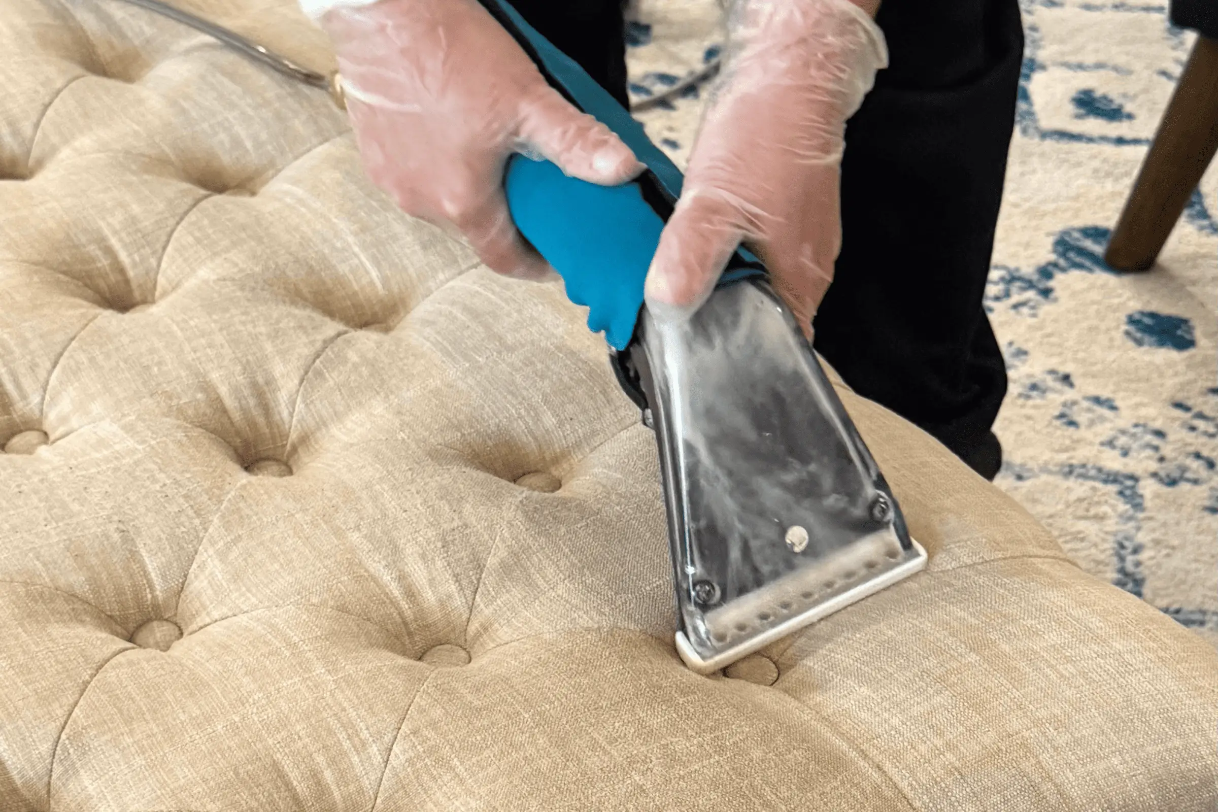 Professional steam upholstery cleaning service on a tufted fabric sofa in Dallas, TX using an extraction tool