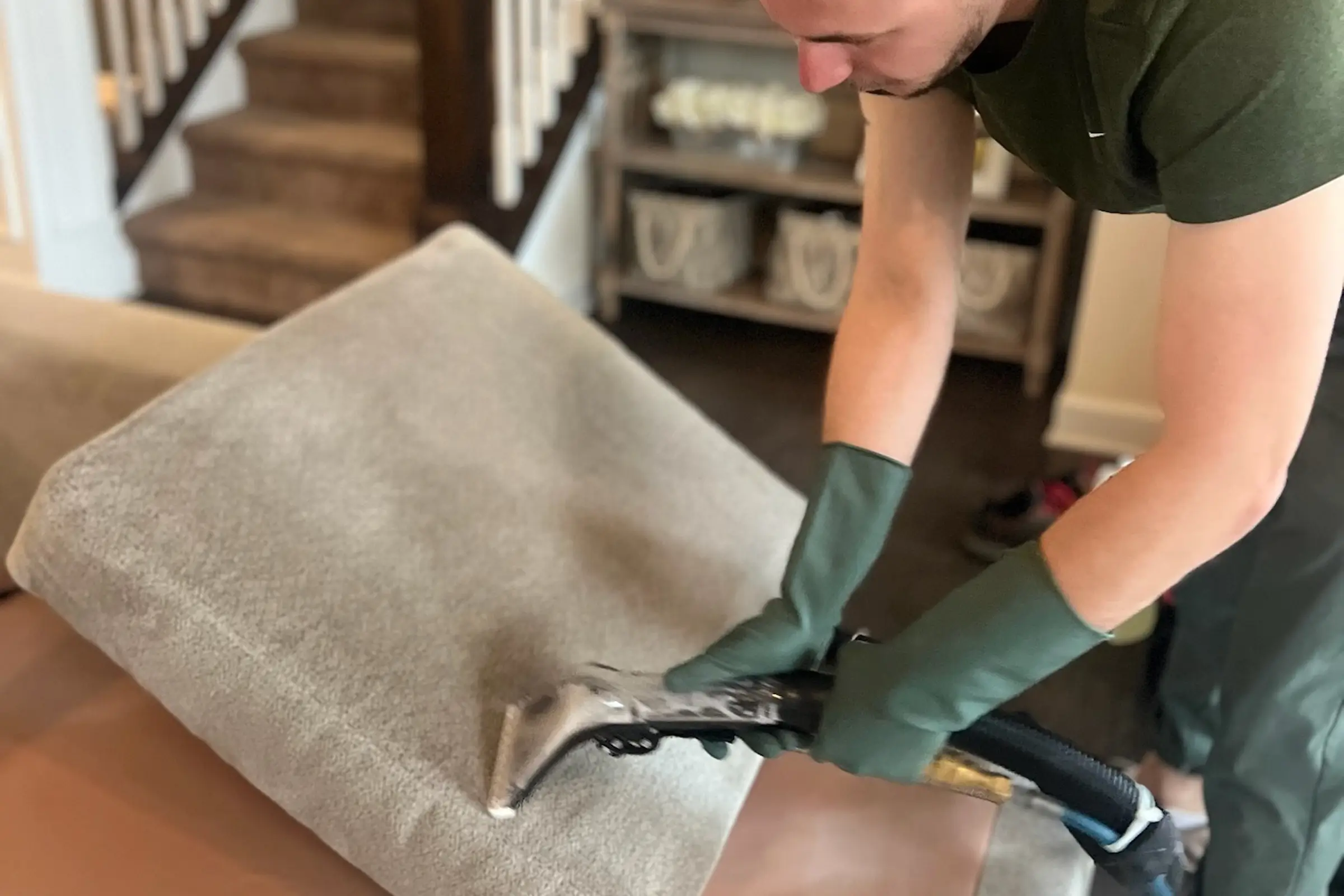 Technician performing steam upholstery cleaning on a couch cushion during couch cleaning in Dallas, TX