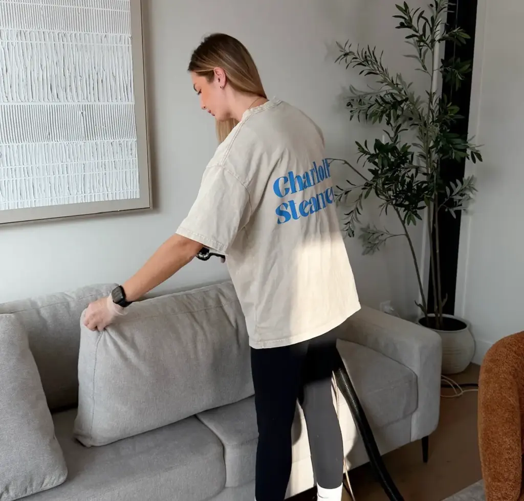 Charlotte Steamers technician lifting a couch cushion during upholstery cleaning in Charlotte, NC